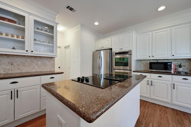 5908 Front Royal Dr, Austin, TX 78746 - kitchen featuring appliances with stainless steel finishes, crown molding, decorative backsplash, white cabinetry, and glass insert cabinets