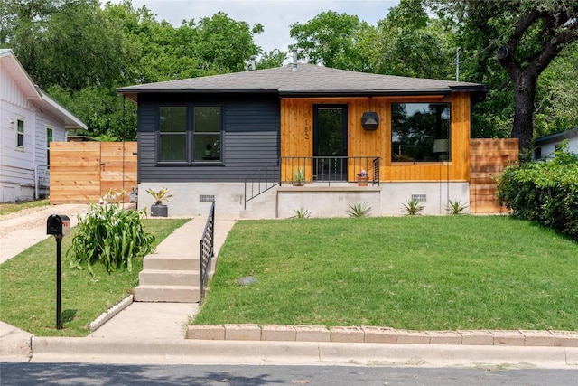 bungalow with fence, a porch, roof with shingles, and a front yard