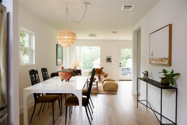 dining space with a notable chandelier, visible vents, and light wood-type flooring