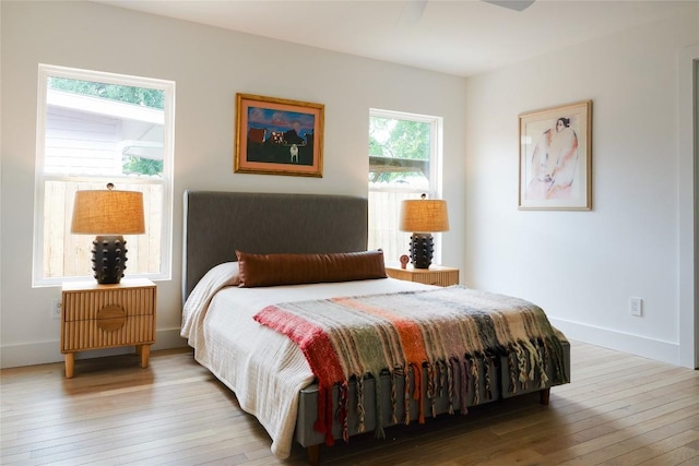 bedroom with wood-type flooring and baseboards