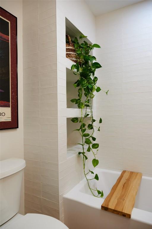 full bathroom with toilet and a washtub