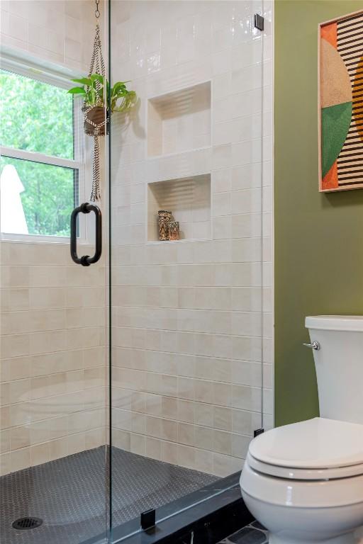 bathroom featuring toilet and a stall shower