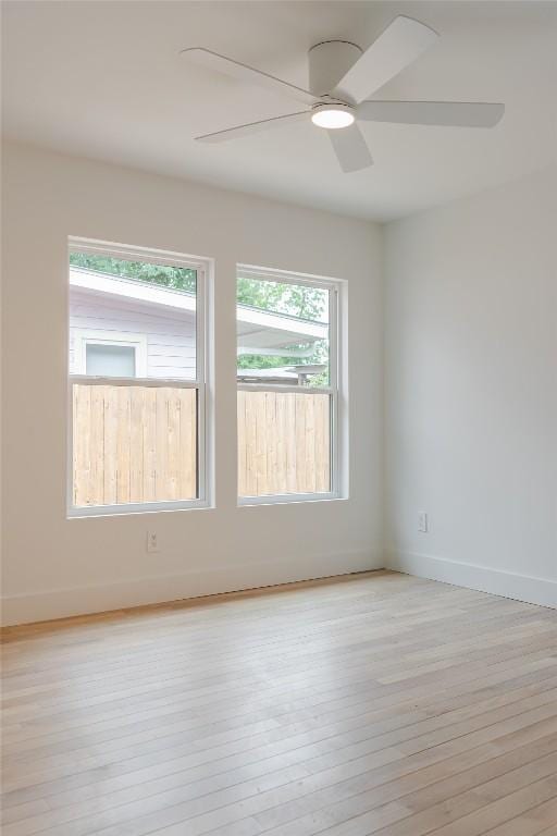 empty room with baseboards, ceiling fan, and hardwood / wood-style flooring