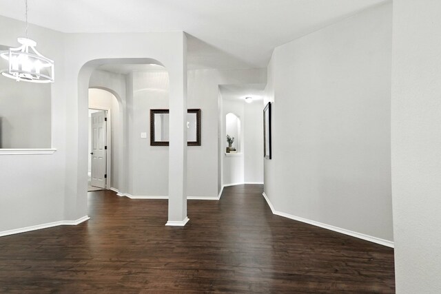 10733 Quarry Oaks Trl, Austin, TX 78717 - interior space featuring an inviting chandelier, baseboards, dark wood-style floors, and arched walkways