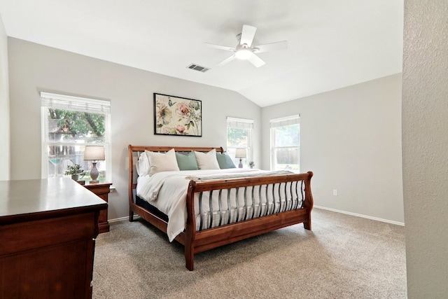 bedroom featuring multiple windows, light carpet, lofted ceiling, and visible vents