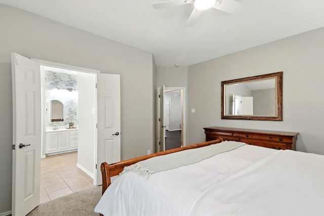 bedroom with light tile patterned flooring, a ceiling fan, and ensuite bath