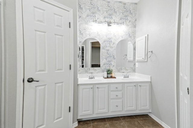 full bath featuring a sink, wallpapered walls, and double vanity