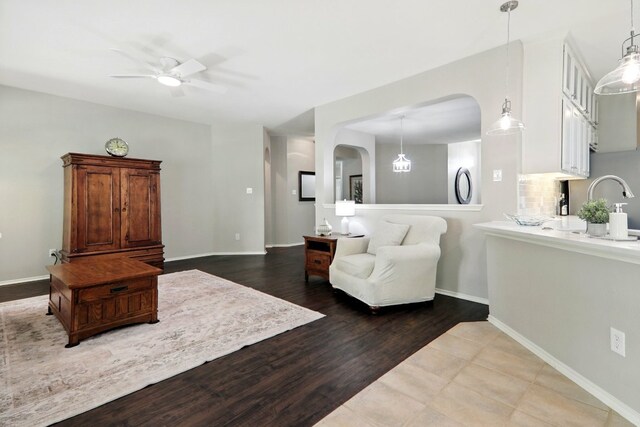 10733 Quarry Oaks Trl, Austin, TX 78717 - living room with wood finished floors, baseboards, a ceiling fan, and arched walkways