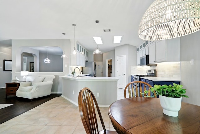 dining area with baseboards, visible vents, and vaulted ceiling