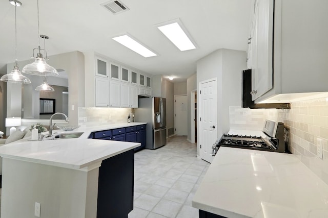 kitchen with blue cabinets, visible vents, a sink, stainless steel fridge with ice dispenser, and range with gas stovetop