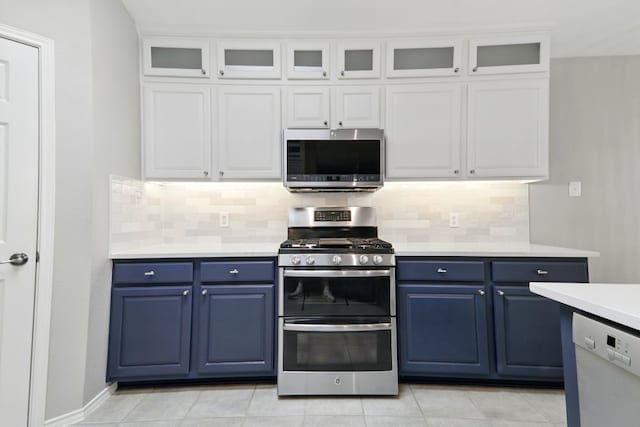kitchen with light countertops, blue cabinetry, backsplash, and stainless steel appliances