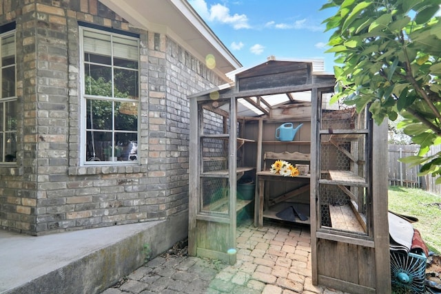 view of side of home with fence and stone siding