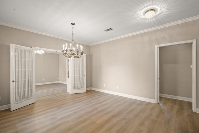 unfurnished dining area featuring crown molding, baseboards, an inviting chandelier, and visible vents