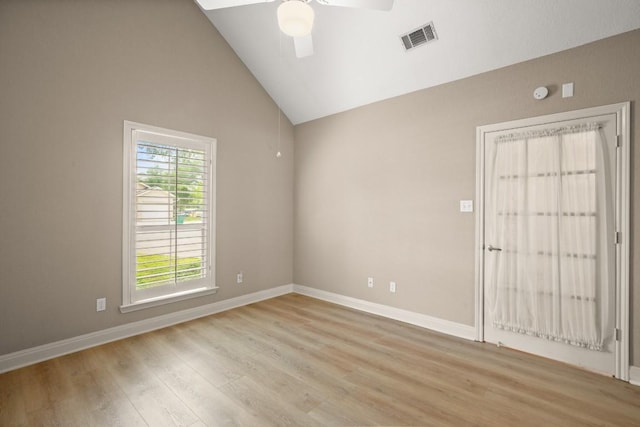 spare room with light wood finished floors, a ceiling fan, baseboards, vaulted ceiling, and visible vents