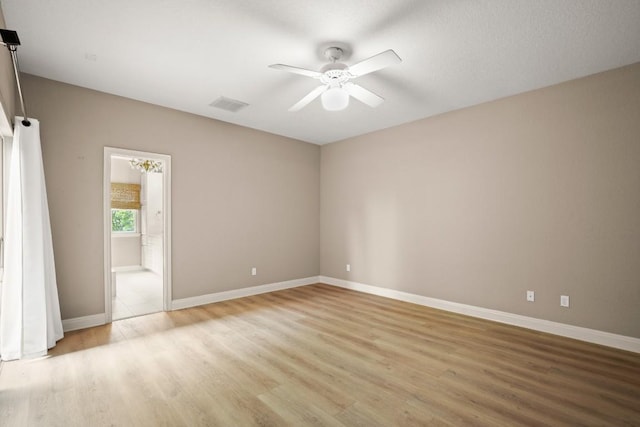 unfurnished bedroom featuring baseboards, visible vents, light wood-style flooring, and ensuite bathroom