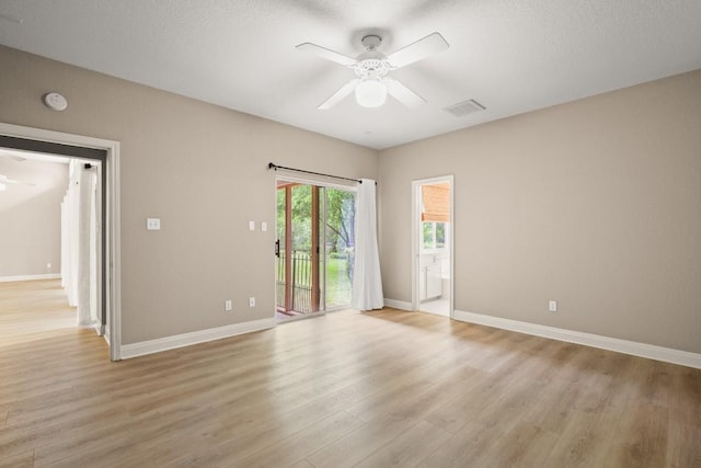 unfurnished room featuring baseboards, ceiling fan, visible vents, and light wood-style flooring