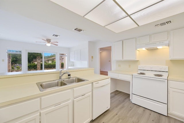 kitchen with white appliances, under cabinet range hood, a sink, and visible vents
