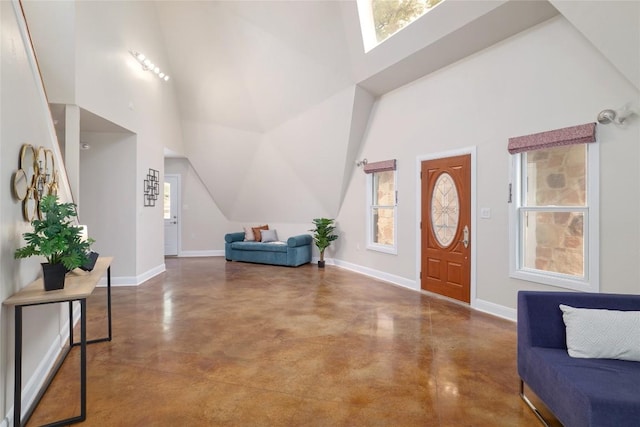 entrance foyer with concrete flooring, a high ceiling, and a wealth of natural light