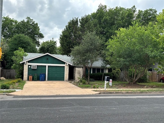 ranch-style house with brick siding, an attached garage, fence, and driveway