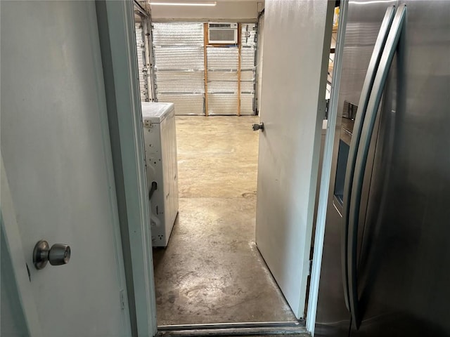 hallway with a wall mounted air conditioner, concrete floors, and washer / clothes dryer