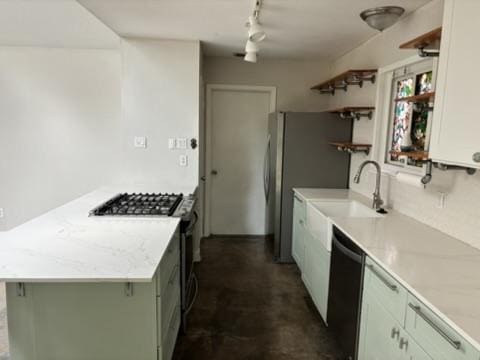 kitchen featuring stainless steel gas range, light countertops, open shelves, and dishwasher