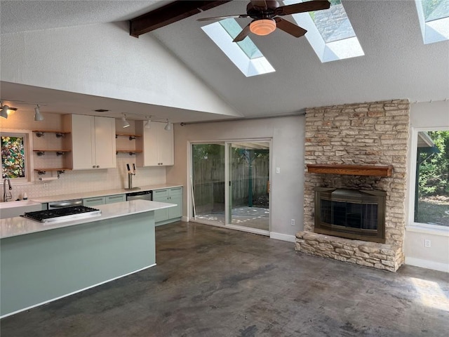 1715 Mearns Mdw, Austin, TX 78758 - kitchen featuring open shelves, lofted ceiling with skylight, light countertops, white cabinetry, and concrete floors