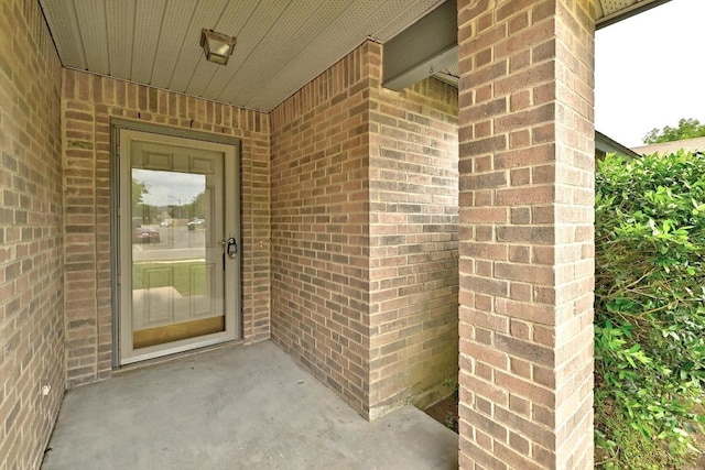 entrance to property featuring brick siding