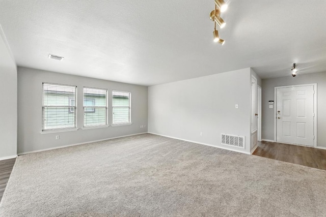 unfurnished room featuring visible vents, carpet flooring, and baseboards