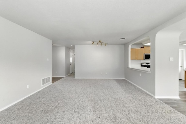 unfurnished living room with visible vents, carpet, and baseboards