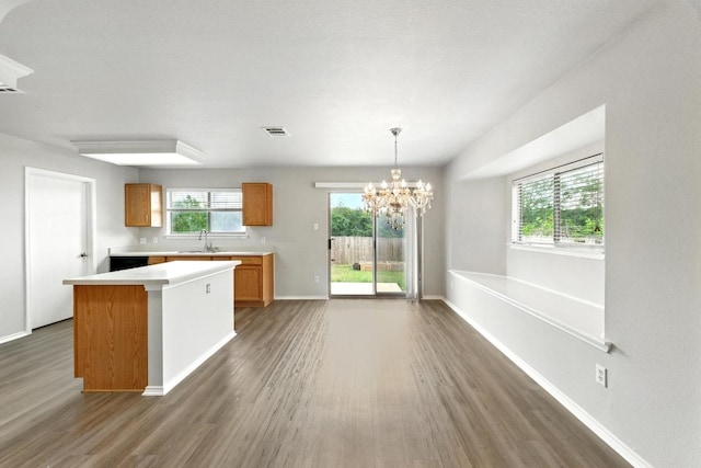 kitchen with visible vents, light countertops, a chandelier, brown cabinets, and dark wood finished floors