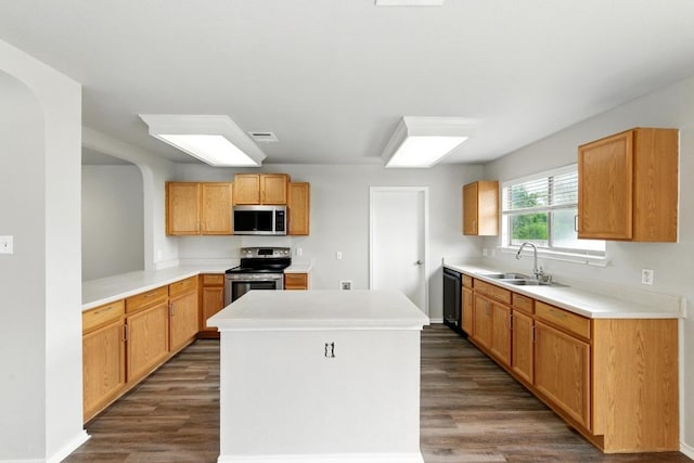 kitchen featuring visible vents, dark wood-type flooring, a center island, a sink, and stainless steel appliances