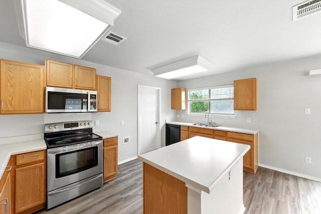 kitchen with a sink, appliances with stainless steel finishes, light wood-type flooring, and visible vents
