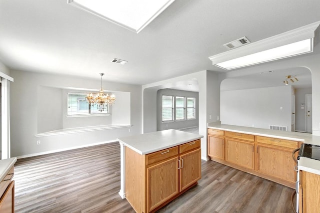 kitchen featuring range with electric cooktop, visible vents, wood finished floors, and light countertops