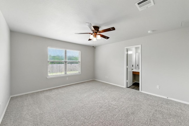 unfurnished bedroom with ceiling fan, visible vents, baseboards, ensuite bathroom, and carpet