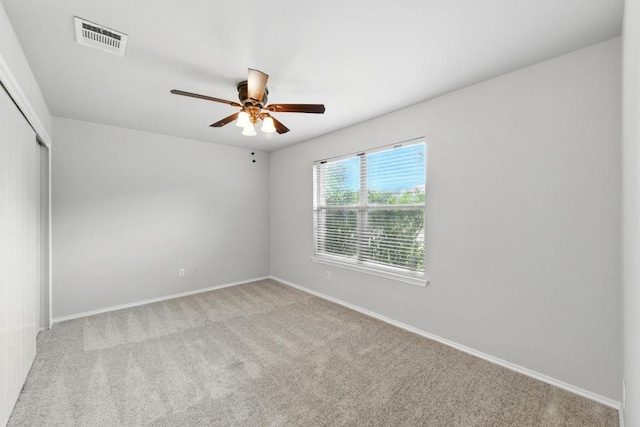 unfurnished room with baseboards, carpet, a ceiling fan, and visible vents