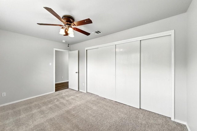 unfurnished bedroom featuring carpet floors, a ceiling fan, baseboards, visible vents, and a closet