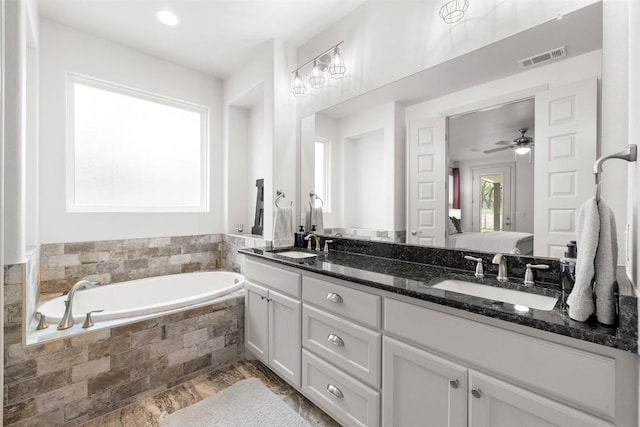 275 Axis Cir, Fredericksburg, TX 78624 - bathroom with ensuite bath, a garden tub, double vanity, and a ceiling fan