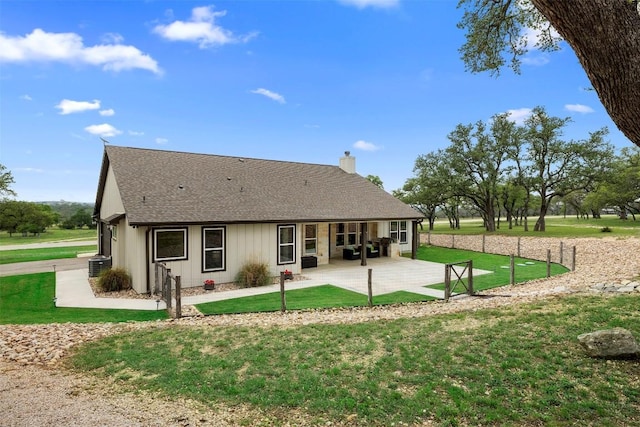 275 Axis Cir, Fredericksburg, TX 78624 - rear view of house featuring a shingled roof, a patio, a chimney, a yard, and central AC unit