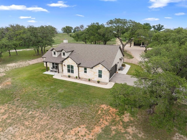 275 Axis Cir, Fredericksburg, TX 78624 - view of front of home featuring an attached garage, stone siding, concrete driveway, a front lawn, and a shingled roof