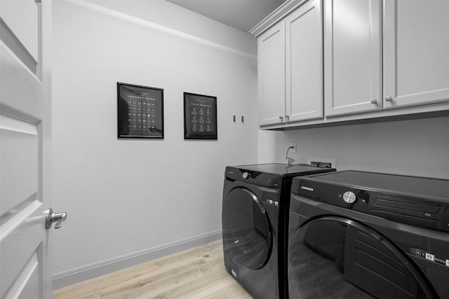275 Axis Cir, Fredericksburg, TX 78624 - clothes washing area featuring washer and clothes dryer, cabinet space, light wood-type flooring, and baseboards