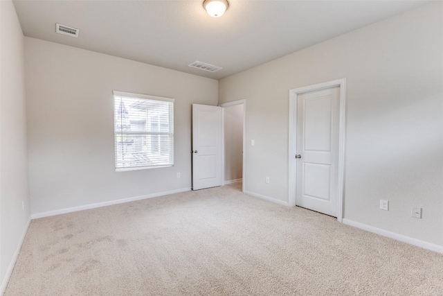 carpeted spare room with baseboards and visible vents
