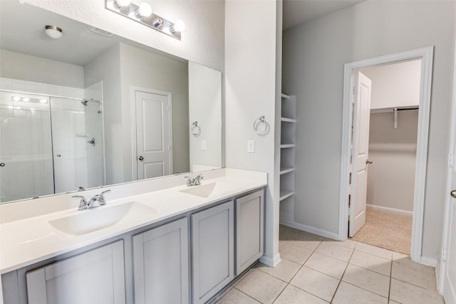 full bathroom with double vanity, a shower stall, a sink, and tile patterned flooring