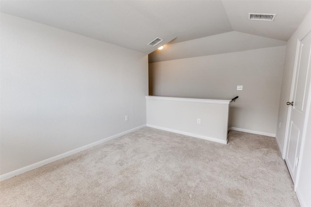 additional living space with visible vents, baseboards, lofted ceiling, and light carpet