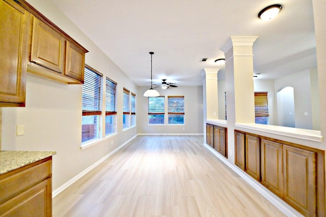 unfurnished dining area featuring baseboards, ceiling fan, and light wood-type flooring