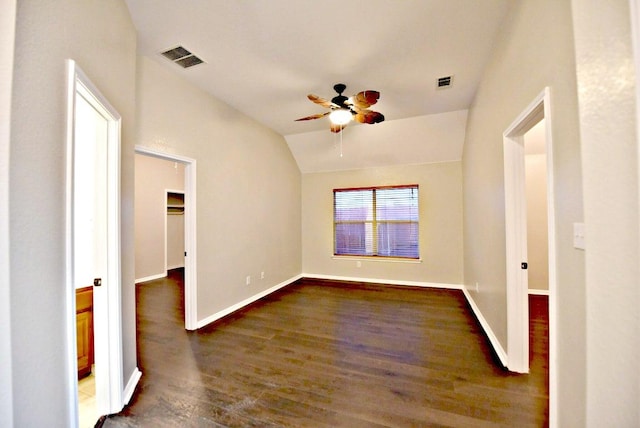 spare room featuring a ceiling fan, baseboards, lofted ceiling, dark wood-type flooring, and visible vents