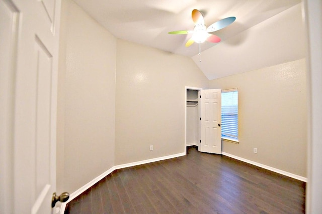 unfurnished bedroom with baseboards, ceiling fan, vaulted ceiling, and dark wood-type flooring