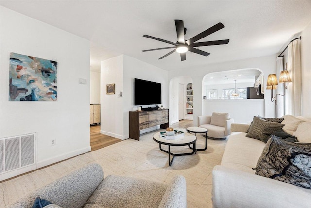 3405 Barksdale Dr, Austin, TX 78725 - living room featuring arched walkways, ceiling fan, and light wood-type flooring