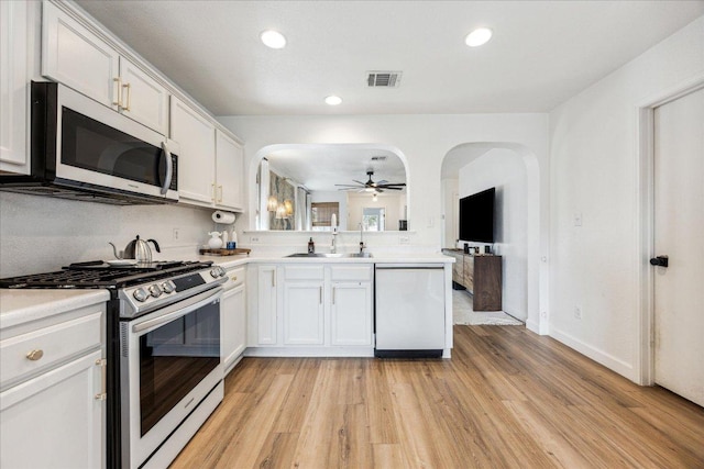 3405 Barksdale Dr, Austin, TX 78725 - kitchen with stainless steel appliances, a ceiling fan, arched walkways, light wood-style flooring, and light countertops