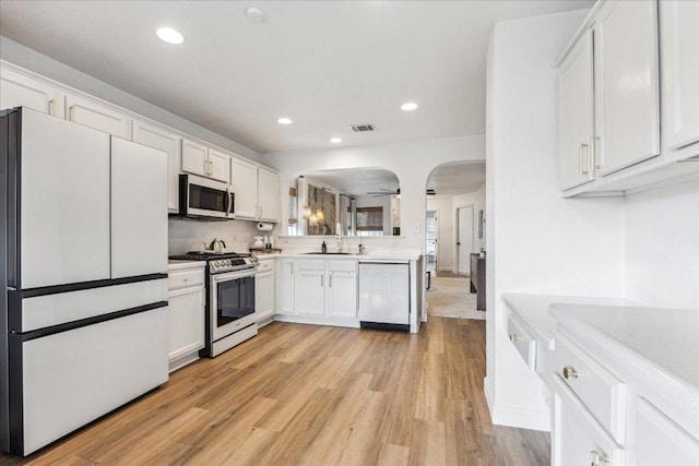 3405 Barksdale Dr, Austin, TX 78725 - kitchen featuring stainless steel appliances, light countertops, recessed lighting, light wood-type flooring, and white cabinets