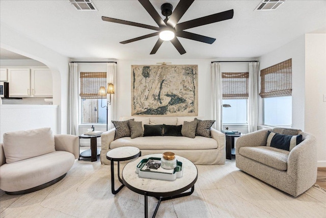 3405 Barksdale Dr, Austin, TX 78725 - living room featuring a ceiling fan, arched walkways, and healthy amount of natural light